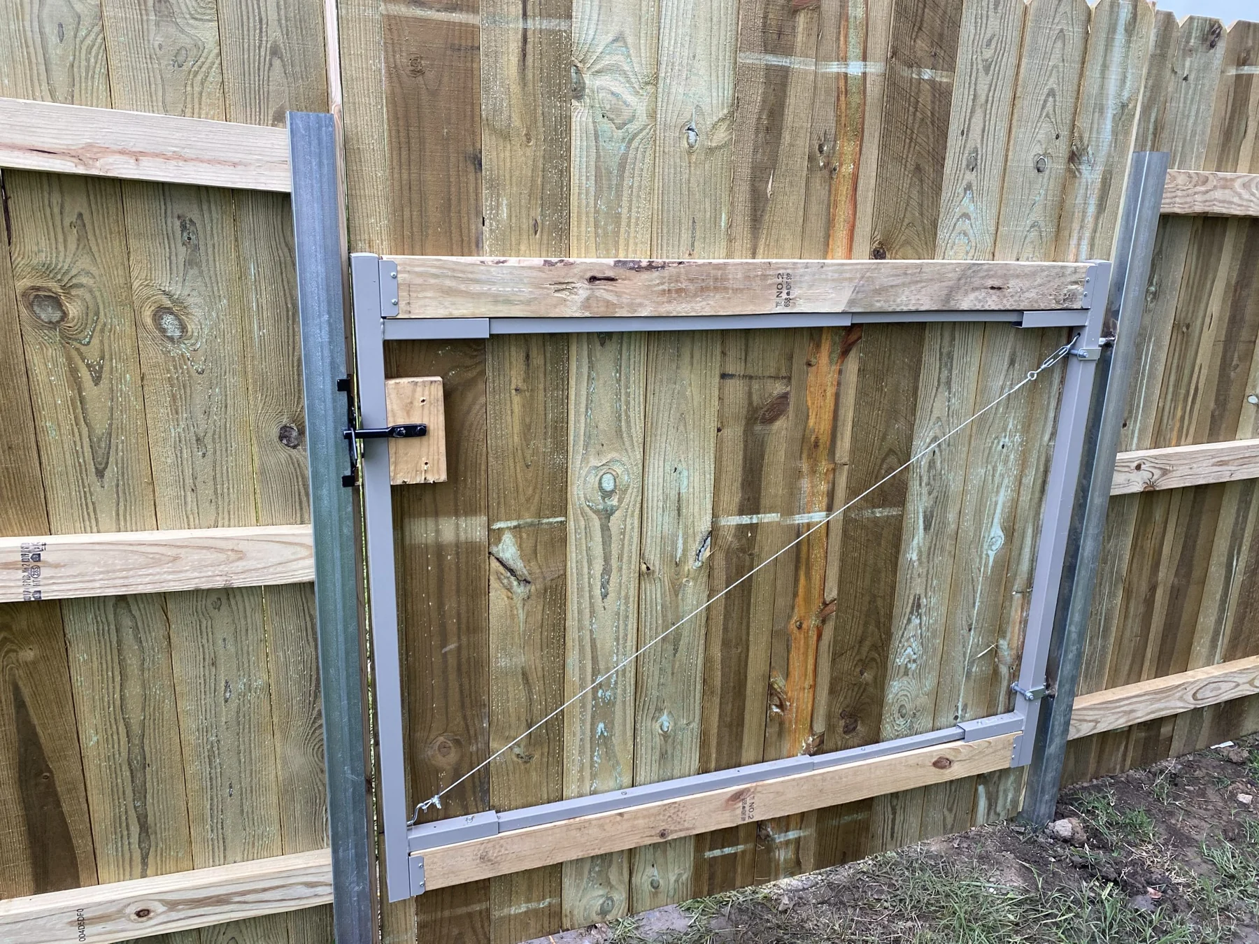 Wood walk gate with metal posts and supporting framework